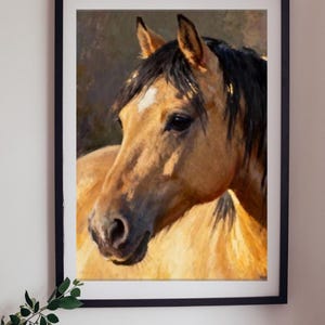 May include: A framed wall art print featuring an oil painting of a buckskin horse head and neck. The horse has a tan coat, a dark mane, and a small white star on its forehead. The artwork is enclosed in a simple black rectangular frame.