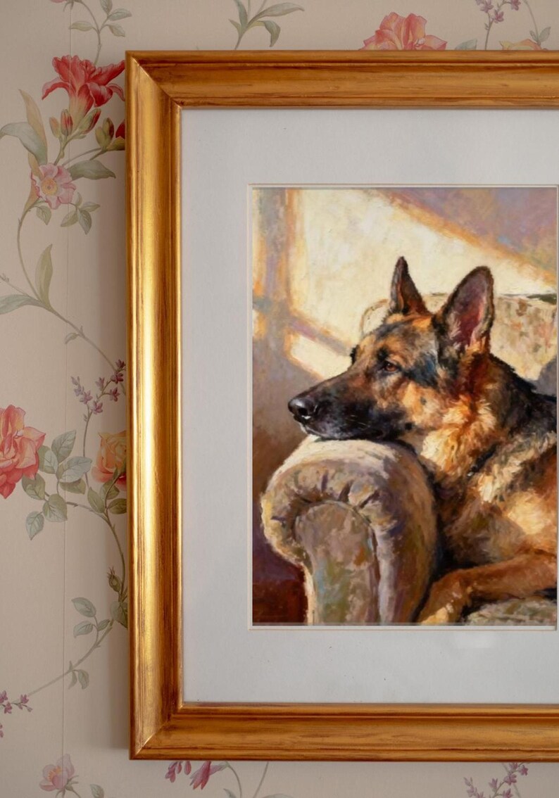 Close-up of the framed German Shepherd print in a gold frame mounted on floral wallpaper.