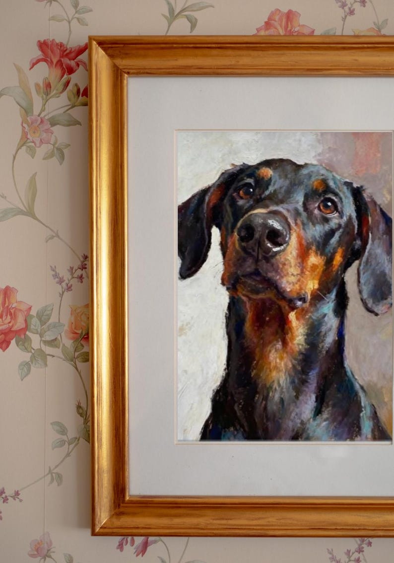 May include: An oil painting of a Doberman Pinscher dog with black and tan fur, captured in a head and shoulders portrait. The artwork is displayed in a rectangular gold-toned frame with a white mat, showcasing visible brushstrokes and texture.