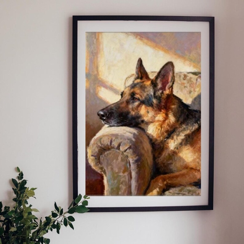 The German Shepherd print in a black frame hanging on a white wall next to a leafy green plant.