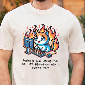 May include: Ivory-colored t-shirt featuring a cartoon cat with a computer, surrounded by flames. The text reads, "Coding is 18% writing code and 98% figuring out why it doesn't work."