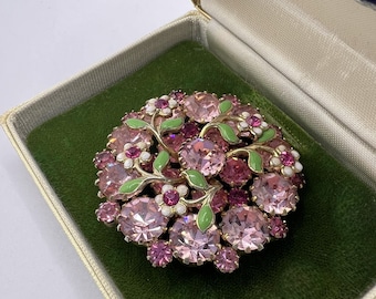 Broche de pedrería AB aurora boreal rosa vintage de los años 1950 con diseño estilizado de flores blancas, verdes y rosas. Engastado en metal dorado.