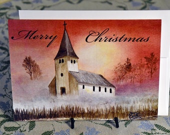 Biglietto di auguri, scena natalizia di una chiesa al tramonto.