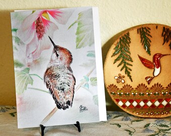 Biglietto di auguri raffigurante un colibrì nel suo elemento.
