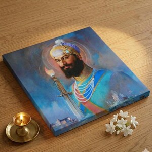 Könnte beinhalten: Leinwanddruck eines Mannes mit Bart, der einen Turban trägt und ein Schwert mit einer brennenden Flamme hält. Das Kunstwerk weist ein blaues und goldenes Farbschema auf, mit einem Halo-Effekt um den Kopf des Mannes. Eine kleine Messinglampe und weiße Blumen befinden sich im Vordergrund.