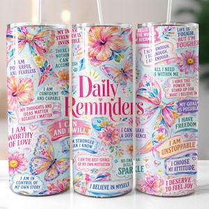 Può includere: Tre bicchieri in acciaio inossidabile da 590 ml con un design floreale e a farfalla. Ogni bicchiere presenta citazioni ispiratrici e le parole "Daily Reminders" in rosa. Hanno uno sfondo azzurro.