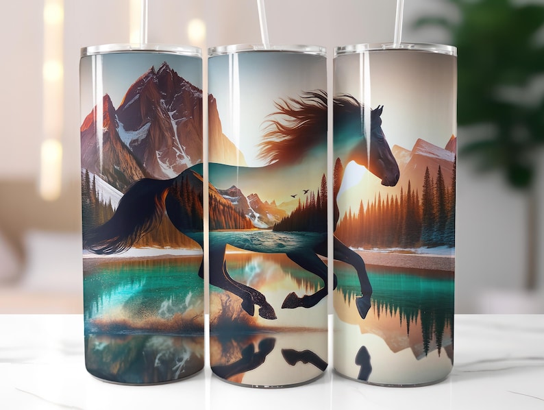 May include: Three stainless steel tumblers with a wraparound design featuring a running horse silhouette superimposed over a mountain and lake landscape. The design incorporates shades of blue, orange, and brown, with a white straw.