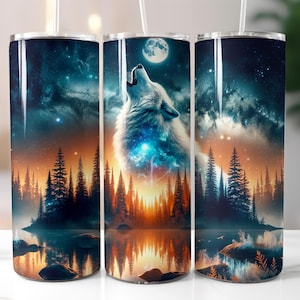 May include: A set of three stainless steel tumblers with a wraparound design featuring a howling wolf under a full moon. The artwork includes a forest, lake, and starry night sky in shades of blue, orange, and black.