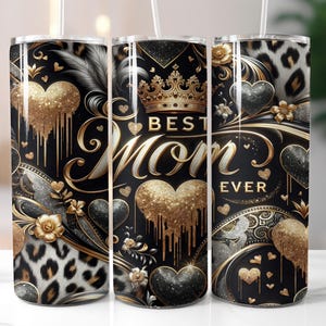 May include: A black tumbler with a gold and silver design, featuring the text "Best Mom Ever" in gold script. The design includes gold hearts, a crown, and a leopard print pattern. A white straw is inserted in the top.