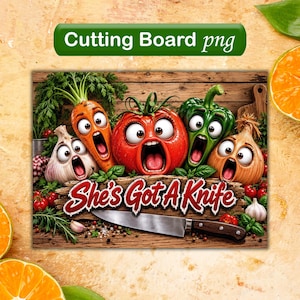 May include: A rectangular cutting board featuring a cartoon illustration of a garlic bulb, carrot, tomato, green bell pepper, and onion with wide-eyed, screaming expressions. The text "She's Got A Knife" is displayed above a silver kitchen knife.