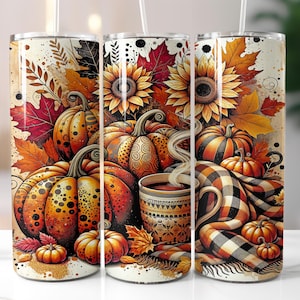 May include: Three stainless steel tumblers with a fall-themed design. The design features pumpkins, sunflowers, and autumn leaves in shades of orange, yellow, and brown. A cup of coffee with steam and a plaid blanket are also depicted.