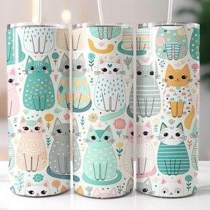 May include: Three stainless steel tumblers with a whimsical cat pattern. The design features various colorful cats with floral and geometric patterns on a white background. Each tumbler has a straw and a lid.