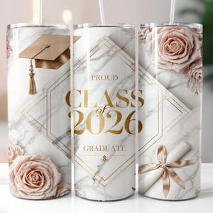 May include: A white marble-effect tumbler with gold detailing and the text "PROUD CLASS OF 2026 GRADUATE." It features a graduation cap, roses, and a rolled diploma with a bow. A stylish gift for a graduate.