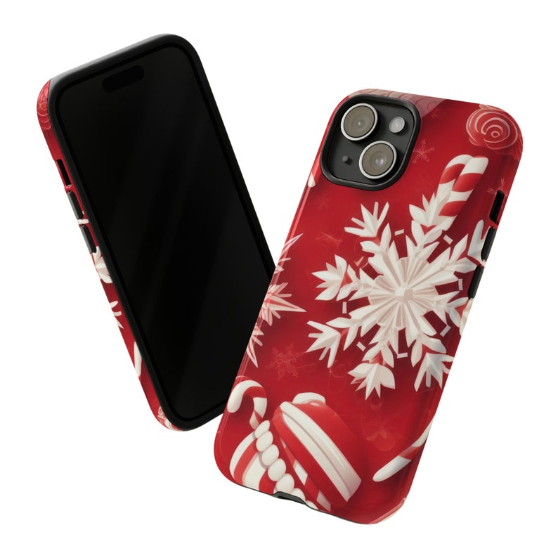 Puede incluir: Una funda de tel&eacute;fono roja con un dise&ntilde;o de copo de nieve blanco y bast&oacute;n de caramelo. La funda tiene un borde negro y un recorte para el objetivo de la c&aacute;mara.