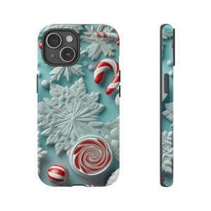 Puede incluir: Una funda de tel&eacute;fono azul con tem&aacute;tica navide&ntilde;a de invierno. La funda presenta copos de nieve blancos, bastones de caramelo rojo y blanco y una piruleta roja y blanca en espiral.