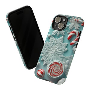 Puede incluir: Una funda de tel&eacute;fono azul con un tema navide&ntilde;o de invierno. La funda presenta copos de nieve blancos, bastones de caramelo y caramelos rojos y blancos.