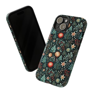 Puede incluir: Una funda de tel&eacute;fono negra con un patr&oacute;n floral que presenta flores y hojas rojas, blancas y verdes sobre un fondo azul oscuro. La funda tiene un recorte para el objetivo de la c&aacute;mara.