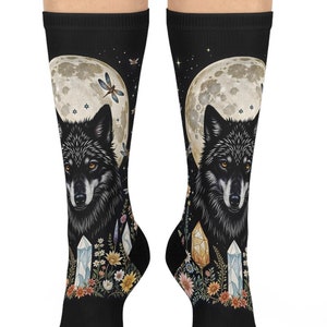 May include: A pair of black socks with a colourful design featuring a wolf howling at the moon, surrounded by crystals and flowers.