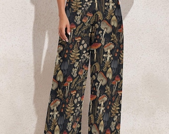 May include: Wide-leg pants with a dark background and a repeating pattern of mushrooms, ferns, and other foliage in shades of red, brown, and beige. The pants have a high waist and a flowing silhouette.
