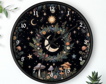 Könnte beinhalten: Eine schwarze Uhr mit weißem Zifferblatt und schwarzen Zeigern. Das Zifferblatt der Uhr zeigt einen zunehmenden Mond, eine Sonne, Sterne und einen Kranz aus Blumen und Pilzen. Die Zahlen auf dem Zifferblatt der Uhr sind in weißer Schrift mit Serifen.