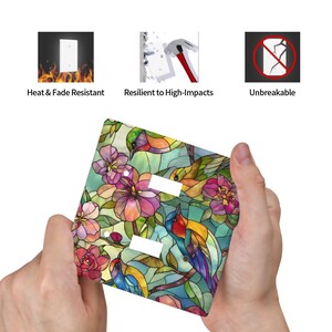 Puede incluir: Una cubierta decorativa para interruptores con un dise&ntilde;o de vidriera con p&aacute;jaros y flores coloridas. La cubierta tiene dos aberturas para interruptores. El texto en la imagen dice: Resistente al calor y a la decoloraci&oacute;n, Resistente a los impactos y Irrompible.