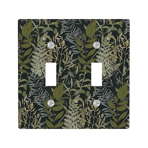 Peut inclure: Un cache-interrupteur double avec un motif botanique. Le couvercle a un fond sombre avec un motif de feuilles et de feuillages verts, olive et gris. La plaque de l'interrupteur comporte deux découpes rectangulaires et deux vis argentées.