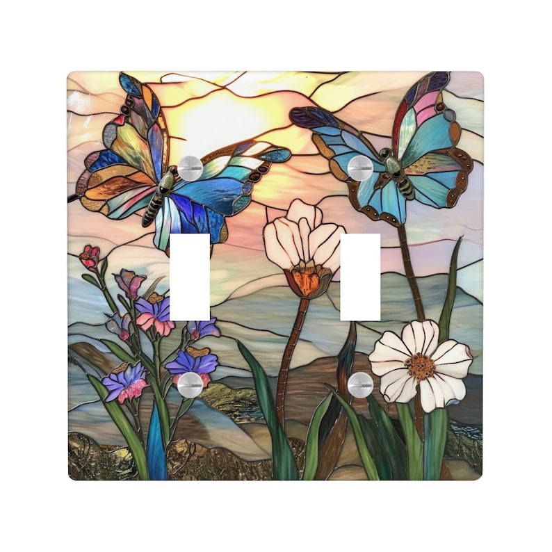 Puede incluir: Una cubierta decorativa para interruptor de luz con un dise&ntilde;o de vidriera que presenta dos mariposas, flores y un fondo de puesta de sol. Las mariposas tienen alas azules, naranjas y marrones. La cubierta tiene dos aberturas para interruptores y tornillos plateados.
