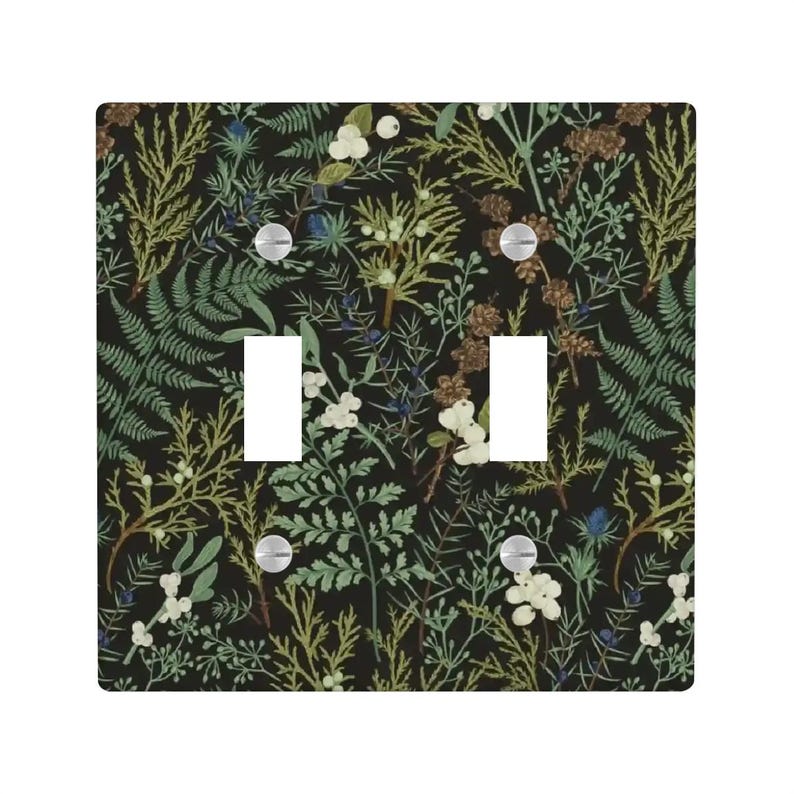 May include: A double light switch cover with a botanical design. The cover features a black background with a pattern of green ferns, white berries, and brown seed heads. The switch plate has two rectangular cutouts and silver screws.