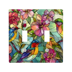 Puede incluir: Una cubierta decorativa para interruptor de luz con un dise&ntilde;o de vidriera que representa p&aacute;jaros y flores. El dise&ntilde;o incluye p&aacute;jaros azules, rojos y amarillos, y flores rosas y naranjas. La cubierta tiene dos aberturas para interruptores.