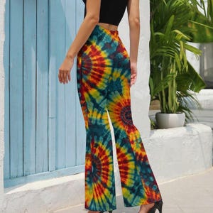 May include: High-waisted, flared pants with a vibrant tie-dye pattern in shades of red, yellow, and teal. The colorful design creates a psychedelic effect. The pants are made of a lightweight fabric and have a wide leg opening.
