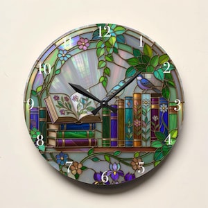 May include: Round wall clock with a stained glass design. The clock face features a bookshelf with books, flowers, and two blue birds. The clock hands are black. The clock is surrounded by a floral border with green leaves and flowers.