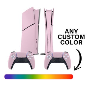May include: A pink gaming console and two matching controllers are displayed against a white background. The console has a sleek, modern design. The text "ANY CUSTOM COLOR" is visible. A color gradient is shown below.