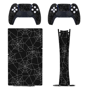 May include: A black PlayStation 5 console and two controllers featuring a white spiderweb pattern. The console is displayed in both horizontal and vertical orientations, with the controllers positioned above. The design covers the entire surface.