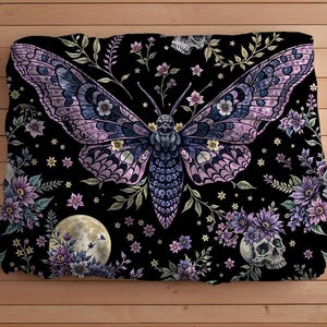 May include: A black and purple floral patterned fabric featuring a large, detailed, purple and pink moth design. The moth has a skull and crossbones design on its body.
