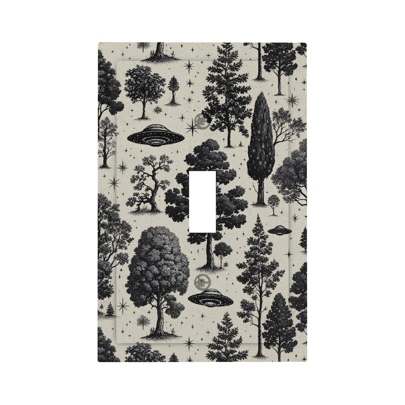 Op de afbeelding: Een lichtschakelaarcover met een zwart-wit illustratie van bomen, sterren en UFO's op een beige achtergrond. Het heeft een opening voor een enkele tuimelschakelaar.