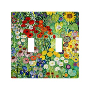 Puede incluir: Una cubierta decorativa para interruptor de luz doble con un dise&ntilde;o floral vibrante. La obra de arte presenta una colorida variedad de flores, incluyendo amapolas rojas, girasoles e iris, sobre un fondo verde. La cubierta tiene dos aberturas para interruptores y tornillos plateados.