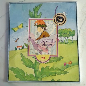 May include: A keepsake growth chart with a whimsical illustration of a fairy and a flower. The chart includes 20 stickers and has measurements up to 60 inches. The box has a gold seal that says "Best Toy Award".