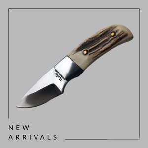 May include: A small, silver, folding knife with a stag horn handle. The knife has a black blade and the words "Linder, Made in Solingen" are engraved on the blade.