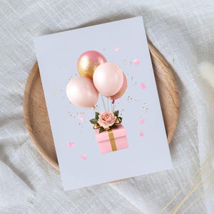 May include: A pink gift box with a gold ribbon is tied with a bow and surrounded by pink and gold balloons. The gift box is sitting on a white background with pink confetti.