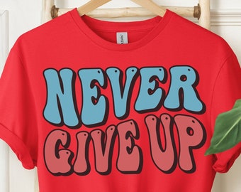 May include: Red t-shirt with the phrase "NEVER GIVE UP" in blue and pink retro lettering.