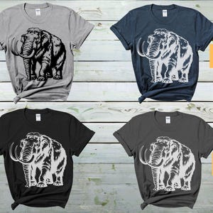 May include: Four t-shirts with a white graphic of a woolly mammoth on a black, dark grey, sport grey, and indigo blue background. The text "Sport Grey Color", "Black Color", "Indigo Blue Color", and "IL Dark Grey Color" is printed on each shirt.