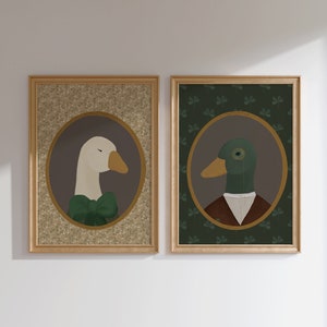 May include: Two framed illustrations of a goose and a duck wearing formal attire. The goose is white with a green bow tie and the duck is green with a brown vest and a white collar. Both illustrations are set against a background of green shamrocks.