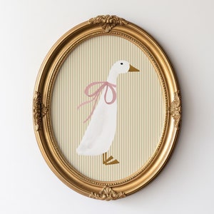 May include: A framed illustration of a white goose with a pink bow, set against a striped background of beige and cream.