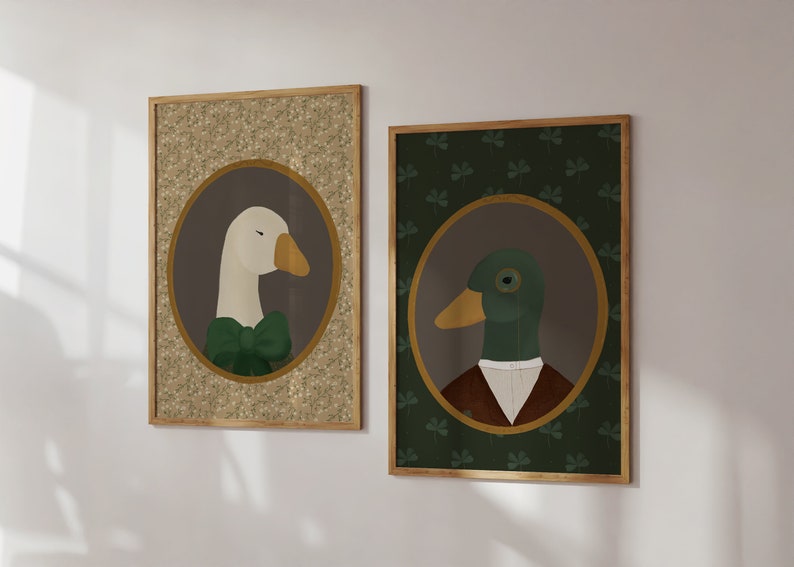 May include: Two framed illustrations of a goose and a duck wearing formal attire. The goose is wearing a green bow tie and the duck is wearing a brown jacket and white collar. The goose illustration has a gold background with a brown floral pattern. The duck illustration has a green background with a clover pattern.