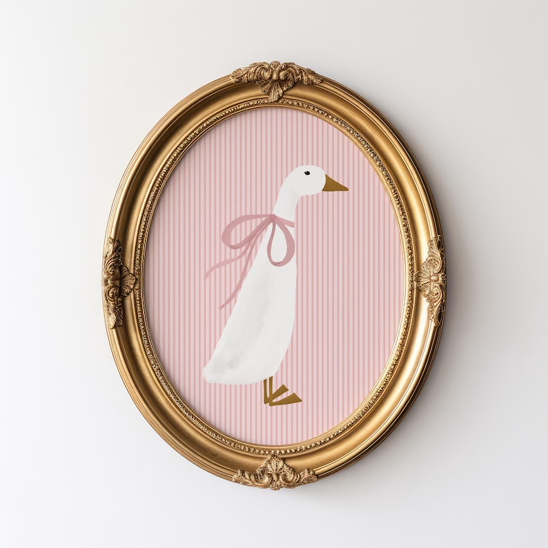 May include: A white goose with a pink bow is depicted on a pink and white striped background. The image is framed in a gold oval frame.