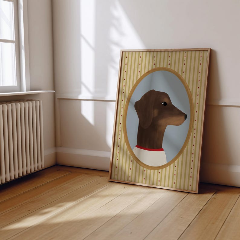 May include: Framed artwork featuring a brown dachshund dog in profile, set against a light blue oval. The dog wears a white shirt with a red collar. The frame has a striped background with a gold border.