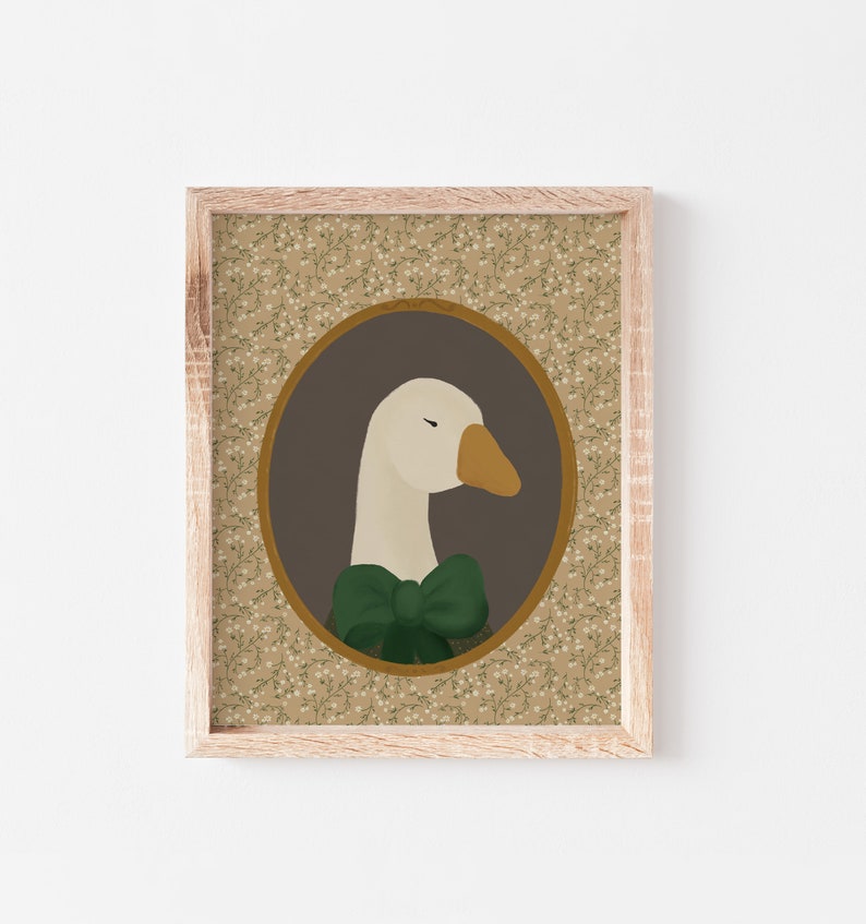 May include: A framed illustration of a white goose wearing a green bow tie. The goose is in a brown oval frame with a floral pattern background.