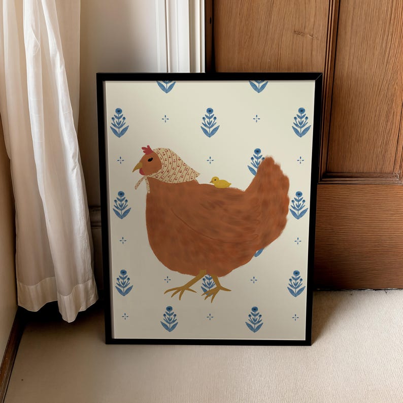 Puede incluir: Una ilustraci&oacute;n enmarcada de una gallina marr&oacute;n con un pa&ntilde;uelo blanco en la cabeza y un peque&ntilde;o pollito amarillo que monta sobre su espalda. El fondo es un patr&oacute;n blanco con dise&ntilde;os florales azules.