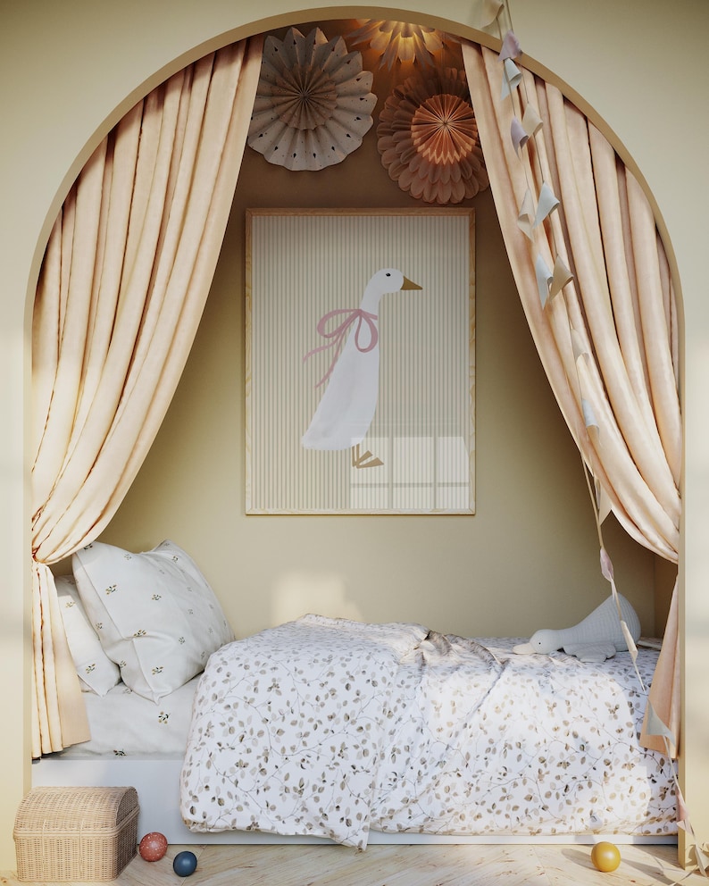 May include: A white bed with a white and brown floral patterned duvet cover and a white pillow with a small floral pattern. The bed is in a nook with beige curtains and a white framed print of a pink-ribboned goose. The print is on a beige wall with paper decorations.