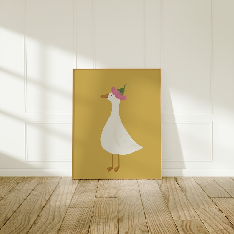 May include: A framed illustration of a white goose wearing a pink flower on its head. The goose is standing on a yellow background.